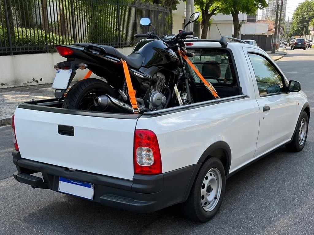 Moto presa com cintas na caçamba de uma picape